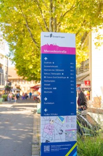 Urban signpost with distances to various destinations in a sunny neighbourhood, Sindelfingen,