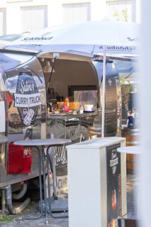 Curry snack van with open front, stainless steel look, shows interior design and menu,