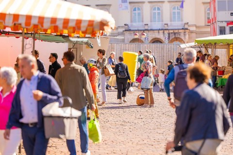 People strolling through a busy market with various stalls and colourful umbrellas, Sindelfingen,