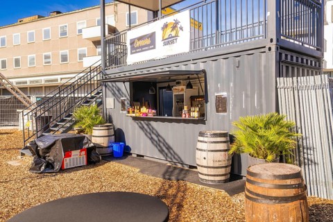 A snack container with barrels and plants outside in the sunshine, open air cinema Sindelfingen,