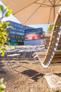 Seating and screen under parasols, sunny urban outdoor area, open air cinema Sindelfingen, district