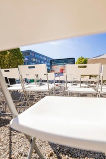 Rows of white chairs in front of an outdoor screen on a sunny day, open air cinema Sindelfingen,
