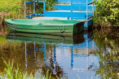 Green boat anchored in front of a blue staircase, Lower Saxony, Germany