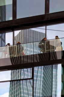 People on the glazed outdoor balcony in a bar with reflection of a skyscraper, Frankfurt am Main,
