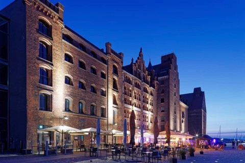 Night shot, outdoor seating, sunshades, restaurant, illuminated, romantic scenery behind, building,