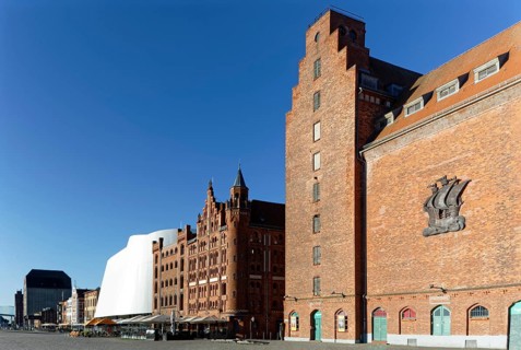 At the front right silo IV, built 1935-36, on windowless wall stylised relief of a cog, behind it