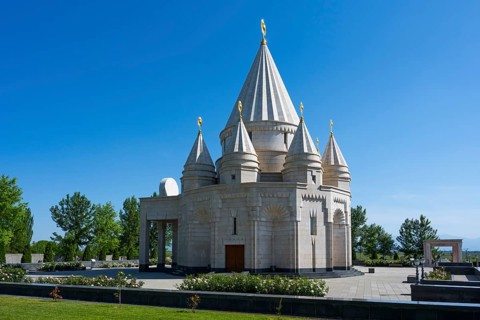 A modern sanctuary with multi-towered architecture under a clear blue sky, Yazidi temple, the