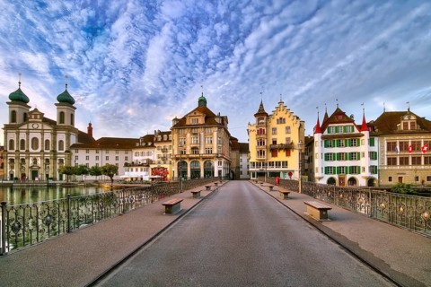 View from the Reuss bridge onto the old town of Lucerne with Jesuit church, decorative cloudy