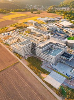 Extensive modern building surrounded by fields, in rural dusk, new hospital building, Calw health