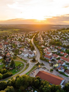 Residential neighbourhood with red roofs and winding streets at a gentle sunset, small town pearl