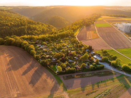 Campsite between forests and fields at sunset with rolling hills, small town Perle Calw, Black