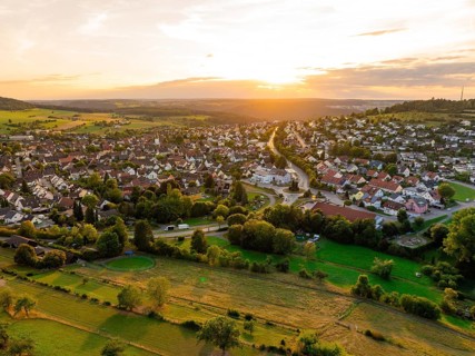 Spacious residential area with open fields and forests at sunset, small town of Perle Calw, Black
