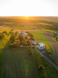 Idyllic landscape with fields and buildings in the warm light of the sunset, small town of Perle