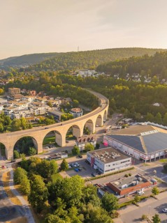Imposing viaduct over a town with surrounding hills and forest at dusk, small town Perle Nagold,