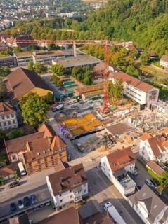 Construction site in the middle of an urban environment with crane and surrounding building