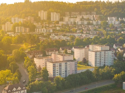 Housing estate in a green, hilly area under warm sunlight, small town of Perle Nagold, Black