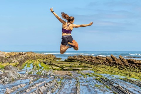 Celebrating freedom and athleticism, a woman leaps with joy amidst the unique geological formations