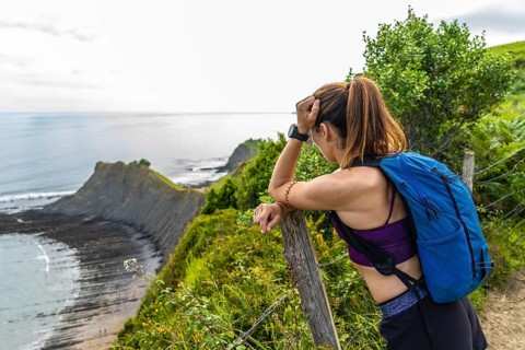 Female hiker enjoying the scenic view of the sakoneta beach and its coastal flysch in zumaia,