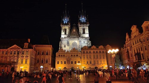 Tourists walking and enjoying old town square and church of our lady before tyn in prague at night