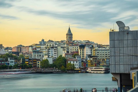 Galata tower rising above colorful buildings along the golden horn in istanbul, turkey, during a