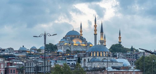 Majestic suleymaniye mosque glowing under cloudy sky at dusk, showcasing istanbul's rich history