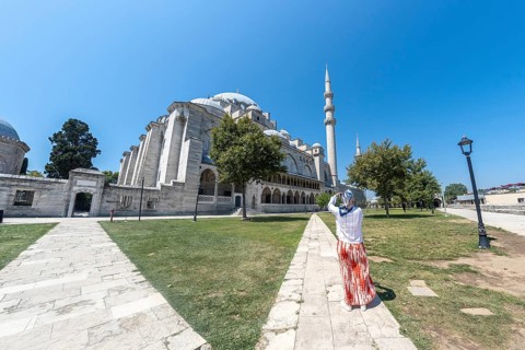 Tourist capturing stunning images of suleymaniye mosque in istanbul on a bright, sunny summer day,