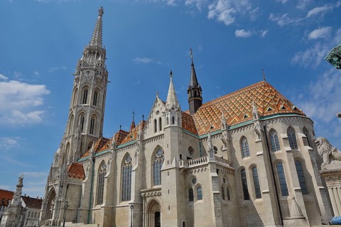 Matthias church with its colorful roof tiles and tall bell tower standing tall against a blue sky