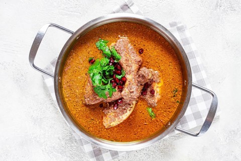 Fesenjan, an Iranian dish, stewed chicken, in a nut-pomegranate sauce, in a saucepan, light