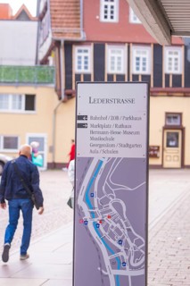 Signpost in a picturesque old town with half-timbered houses in the background, small town pearl