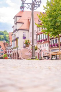 A pink bicycle in front of picturesque half-timbered houses on a sunny square, small town of Perle