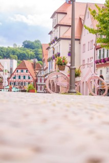 A pink bicycle decorates the street in front of a row of historic houses, small town of Perle Calw,