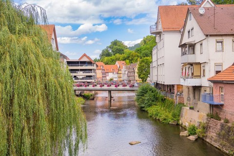 Bridge over a river with hanging willows and neighbouring town buildings, small town of Perle Calw,
