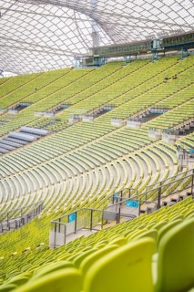 Detailed view of green rows of seats in a modern stadium with glass roof structure, Olympic Park,
