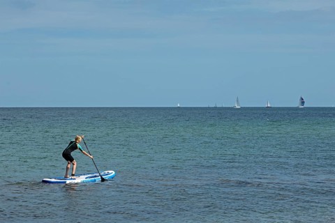 Girl stand-up paddling, Strande, Schleswig-Holstein, Germany