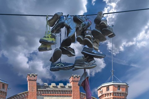 Shoes hanging on a leash in the courtyard of a residential home for addicts, each shoe a reminder