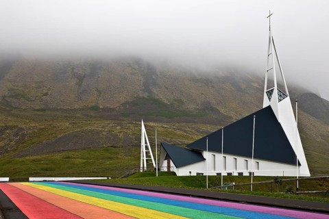 Street painted in the colours of the rainbow and the fish-shaped church designed by Hákon