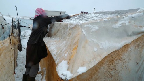 Displaced Syrian families and children living in refugee camps during harsh winter conditions,