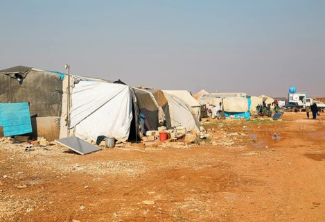 Worn-out tents housing Syrian refugees near the Turkish border, showing the dire humanitarian