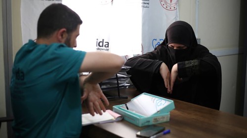 A doctor examining a woman inside a mobile medical point dedicated to treating Syrian refugees.