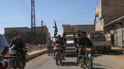 Fighters from the Free Syrian Army celebrate victory after capturing villages that were under the
