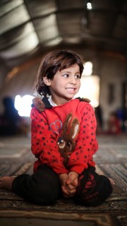 A Syrian refugee child photographed in a camp, reflecting the harsh living conditions of displaced