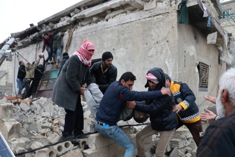 Civil defense teams attempt to rescue civilians trapped under the rubble after a powerful