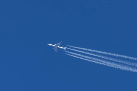 Airbus A340-300 jet aircraft of Lufthansa airlines in flight in a blue sky with vapour trails or