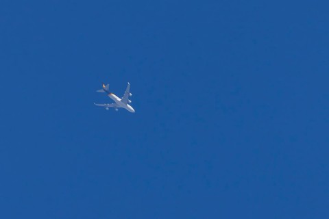 Boeing 747 jumbo jet cargo aircraft of UPS United Postal Service flying in a blue sky, England,