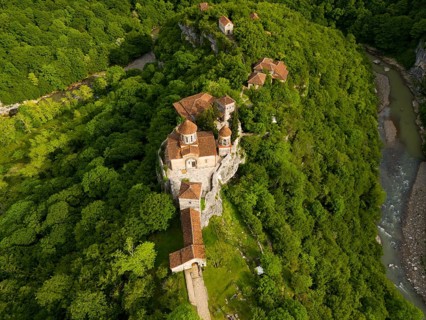 Aerial view of a monastery in the middle of a green forest, near a river, aerial view, Motsameta