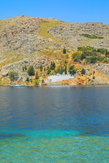 View of the ocean and monastery in the distance from Nimborio Beach, Nimborio, Symi Island,