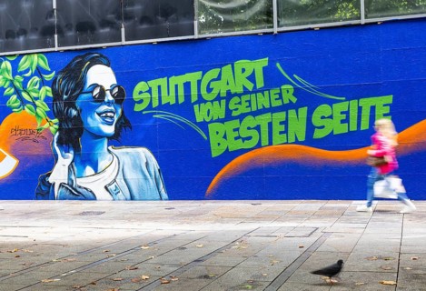 People on the move in the Königstraße pedestrian zone in Stuttgart. Construction fence with the