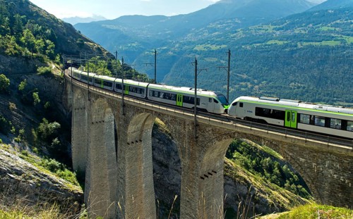 Two coupled RABe 528 multiple units of the BLS AG railway company cross the Luogelkin Viaduct on
