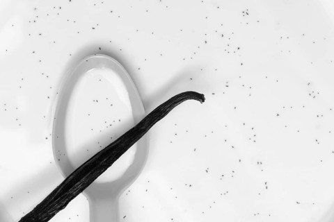 Spoon with vanilla pod, vanilla seeds in milk