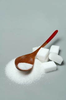 Sugar with wooden spoon and sugar cube